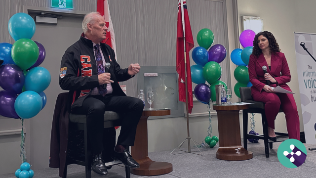 Photo of Oshawa Mayor Dan Carter and Jennifer Alsop from Ontario Tech University in conversation at the Oshawa Chamber of Commerce 2025 Mayor's State of the City Luncheon, overlain with article title Mayor Carter’s Vision: Key Insights from Oshawa’s Luncheon