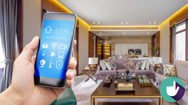Stock photo of person in a living room using mobile phone to operate home automation